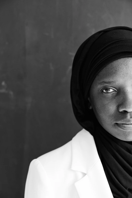 a black and white photo of a woman in a turban, a black and white photo, hurufiyya, adut akech, wearing white silk hood, taken in the late 2010s, black teenage girl