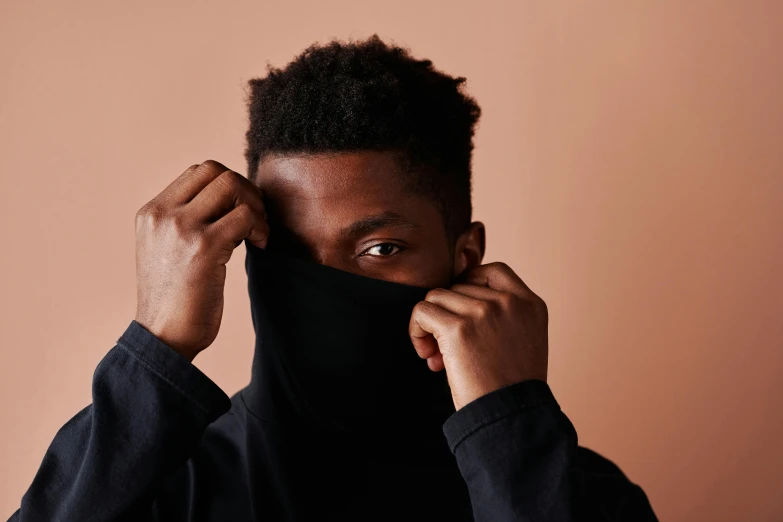 a man wearing a black hood covering his face, trending on pexels, brown skinned, black turtle neck shirt, ignant, wearing a black shirt