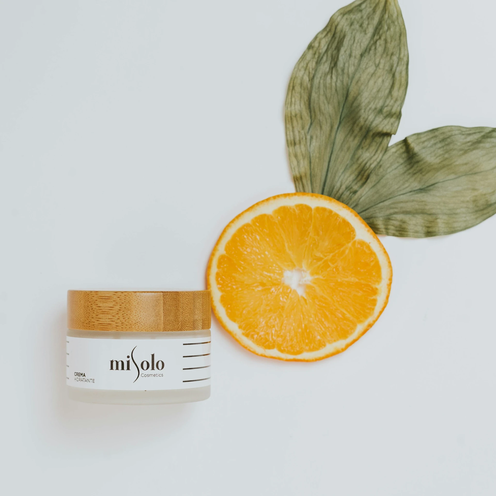 a jar of cream next to an orange on a white surface, a picture, by Miyamoto, lyco art, photoshoot for skincare brand, profile image, mulato, on simple background