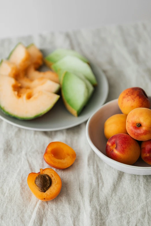 a close up of a bowl of fruit on a table, by Kristin Nelson, unsplash, peach and goma style, still life photo of a backdrop, white, ingredients on the table