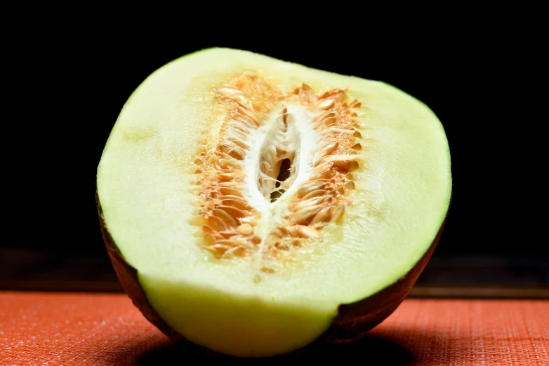 a half of a melon sitting on top of a table, a macro photograph, by Matthias Stom, unsplash, hurufiyya, big hazel nut brown eyes, cut-away, thumbnail, no cropping