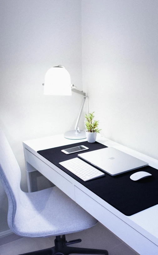 a laptop computer sitting on top of a white desk, a room, lamp, white gallery, led lighting