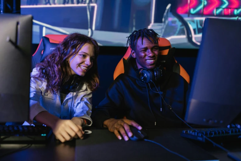 a couple of people that are sitting in front of a computer, pexels, interactive art, gaming chair, blue and orange lighting, both laughing, server in the middle