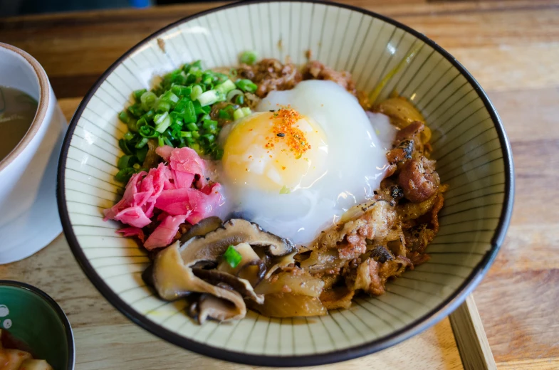 a bowl of food sitting on top of a wooden table, mingei, fan favorite, moco, digging, very crispy