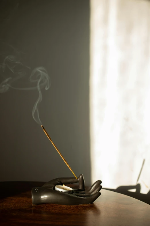 a cigarette sitting on top of a wooden table, incense, bathed in light, profile image, botanicals