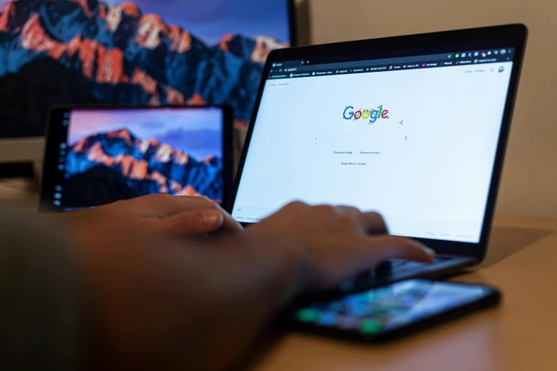 a close up of a person typing on a laptop, by Carey Morris, pexels, google logo, computer monitors, ad image, by greg rutkowski