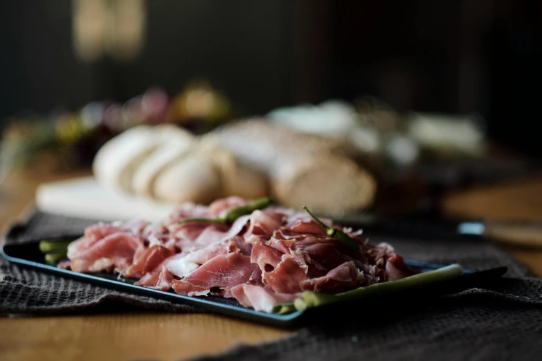 a close up of a plate of food on a table, salami, offering a plate of food, looking off to the side