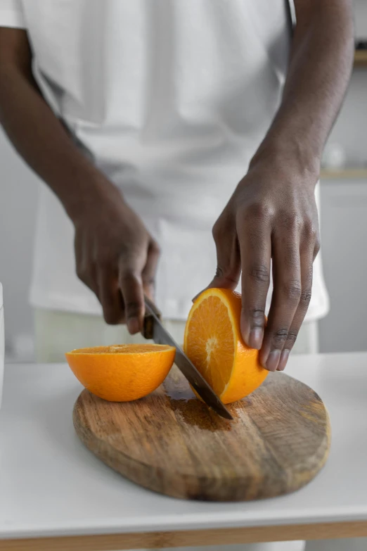 a person cutting an orange on a cutting board, dark-skinned, deeply hyperdetailed, half moon, 2019 trending photo