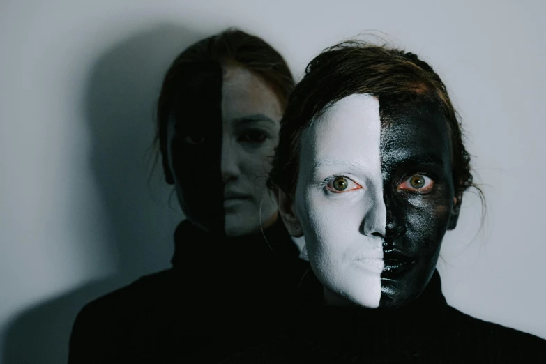 two people with their faces painted black and white, inspired by Nicola Samori, antipodeans, she half human and half robot, duochrome, makeup, reflective skin