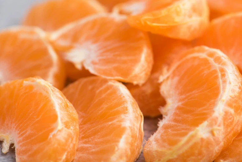 a pile of peeled oranges sitting on top of a table, by Carey Morris, pexels, salmon, light orange mist, 🦩🪐🐞👩🏻🦳, neck zoomed in