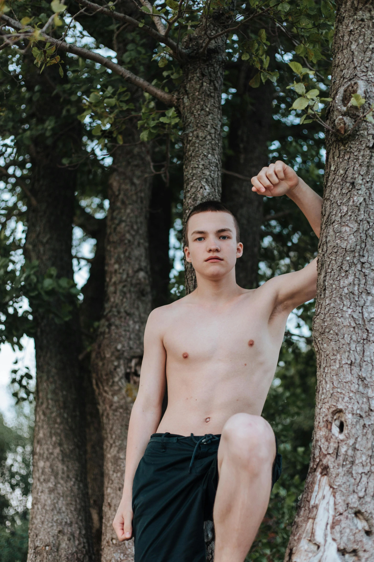 a shirtless young man standing next to a tree, 2019 trending photo, (12x) extremely pale white skin, dasha taran, portrait photo