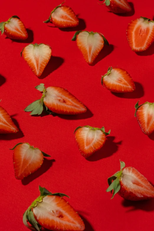 a bunch of strawberries sitting on top of a red surface