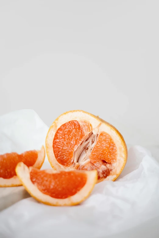 a close up of a grapefruit cut in half, a still life, trending on pexels, on white paper, orange robe, award-winning crisp details”, thick lining