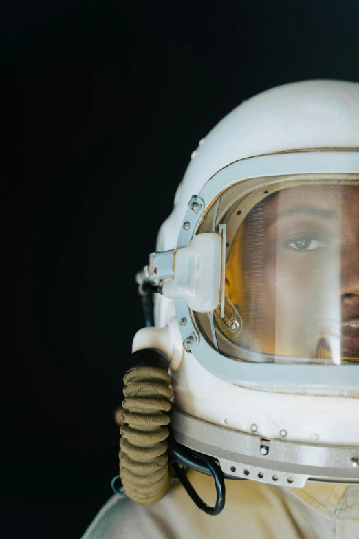 a close up of a person wearing a space suit, by Alison Geissler, trending on unsplash, afrofuturism, 1 9 6 0 s space girl, white helmet, photographed for reuters, exhibit