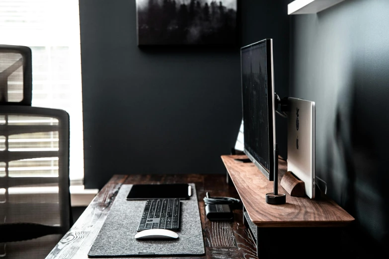 a computer sitting on top of a wooden desk, by Carey Morris, unsplash, simple wood shelves, grey and dark theme, gaming room, mixed materials