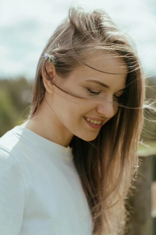 a woman looking down at her cell phone, unsplash, happening, hair waving in the wind, smiling softly, ukrainian girl, round jawline