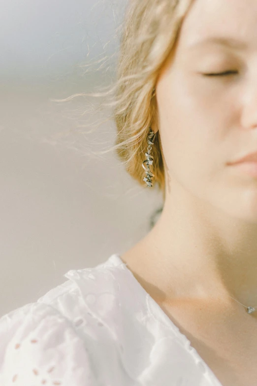 a woman holding a cell phone to her ear, unsplash, light and space, silver filigree details, delicate embellishments, portrait of nordic girl, godly and ethereal