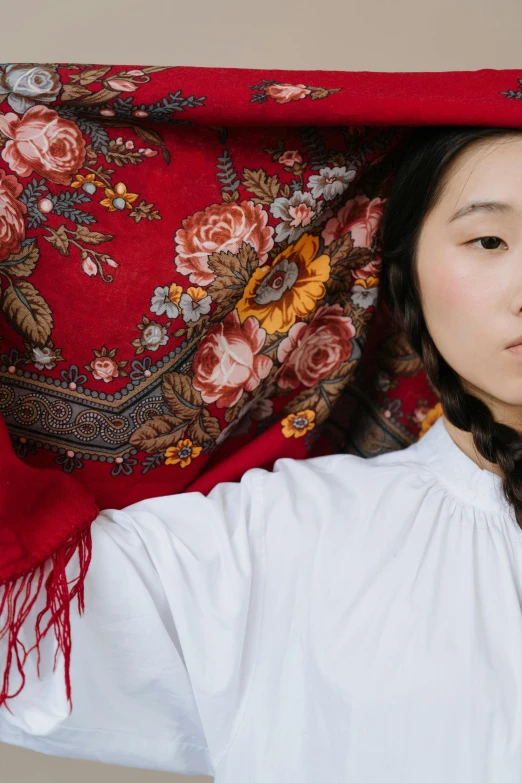 a woman holding a red scarf over her head, an album cover, inspired by Kim Tschang Yeul, trending on unsplash, cloisonnism, ukrainian girl, linen, wearing victorian rags, young asian woman