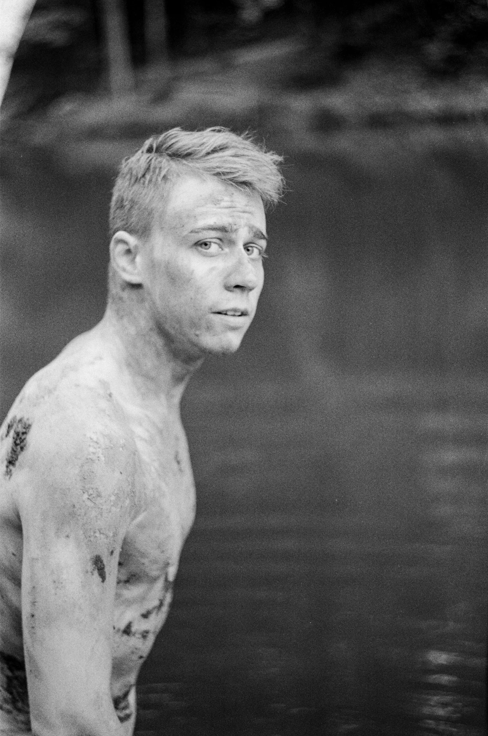 a black and white photo of a man in the water, inspired by Samu Börtsök, with a bruised face and bruises, albino skin, portrait of combat dancer, of a shirtless