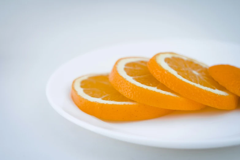 a white plate topped with sliced oranges on top of a table, profile image, 33mm photo, 王琛, high quality product image”