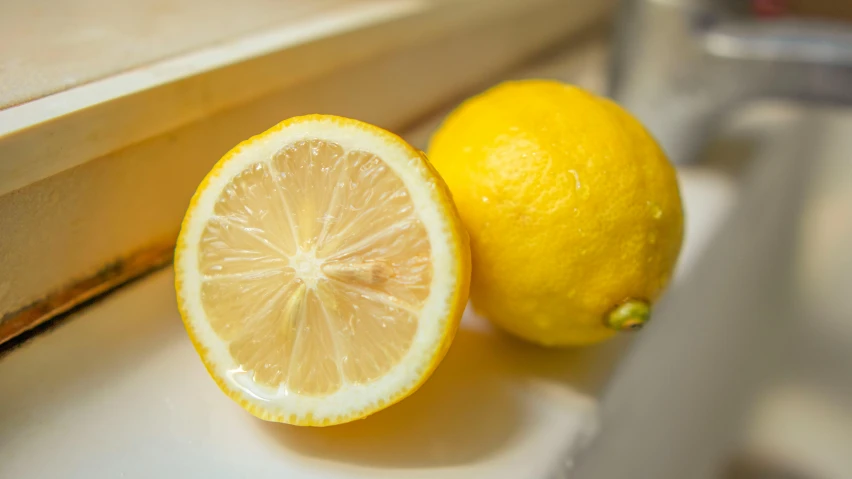 two lemons sitting next to each other on a window sill, a picture, by Susan Weil, unsplash, ingredients on the table, medium closeup, no cropping, with a whitish