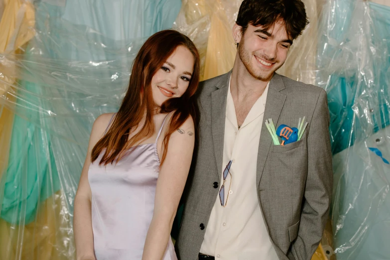 a man and a woman standing next to each other, an album cover, by Anita Malfatti, pexels contest winner, wearing a light blue suit, charli bowater and artgeem, nick drnaso, both smiling for the camera