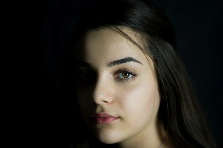 a close up of a woman with a cell phone, inspired by Elsa Bleda, pexels contest winner, hyperrealism, dark thick eyebrows, standing with a black background, 19-year-old girl, headshot profile picture