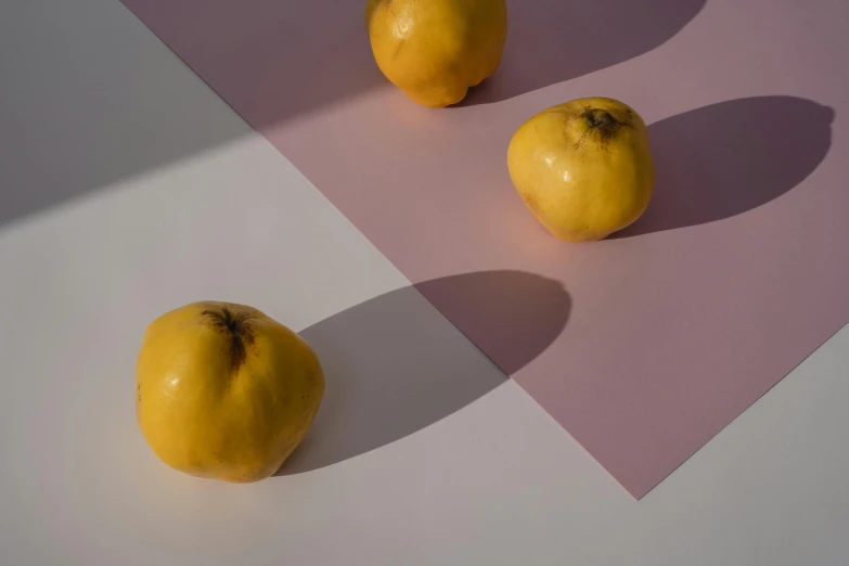 a couple of lemons sitting on top of a table, inspired by Weiwei, unsplash, minimal pink palette, shadow gradient, yellow apples, ignant