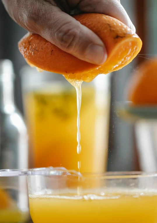 a person squeezing an orange into a glass of juice, multiple stories, thumbnail, cocktail bar, freezing