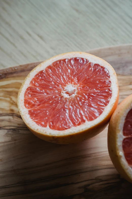 a grapefruit cut in half on a cutting board, unsplash, award-winning crisp details”, natural soft rim light, nice face, subtle detailing