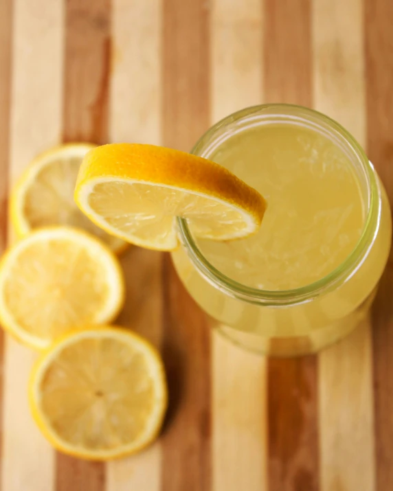 a glass of lemonade sitting on top of a wooden table, promo image, zoomed out, mead, thumbnail