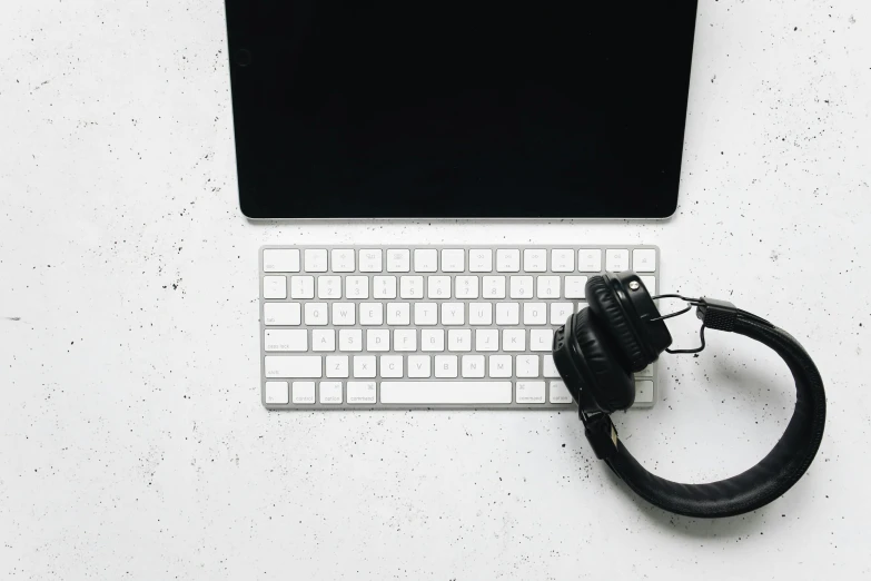 a laptop computer sitting on top of a white desk, an album cover, pexels, wearing black headphones, background image, keyboards, simple white background