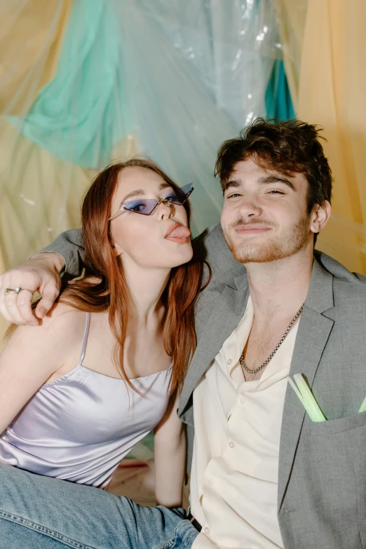 a man and a woman sitting next to each other, an album cover, trending on pexels, college party, brunette boy and redhead boy, pastels, photo booth