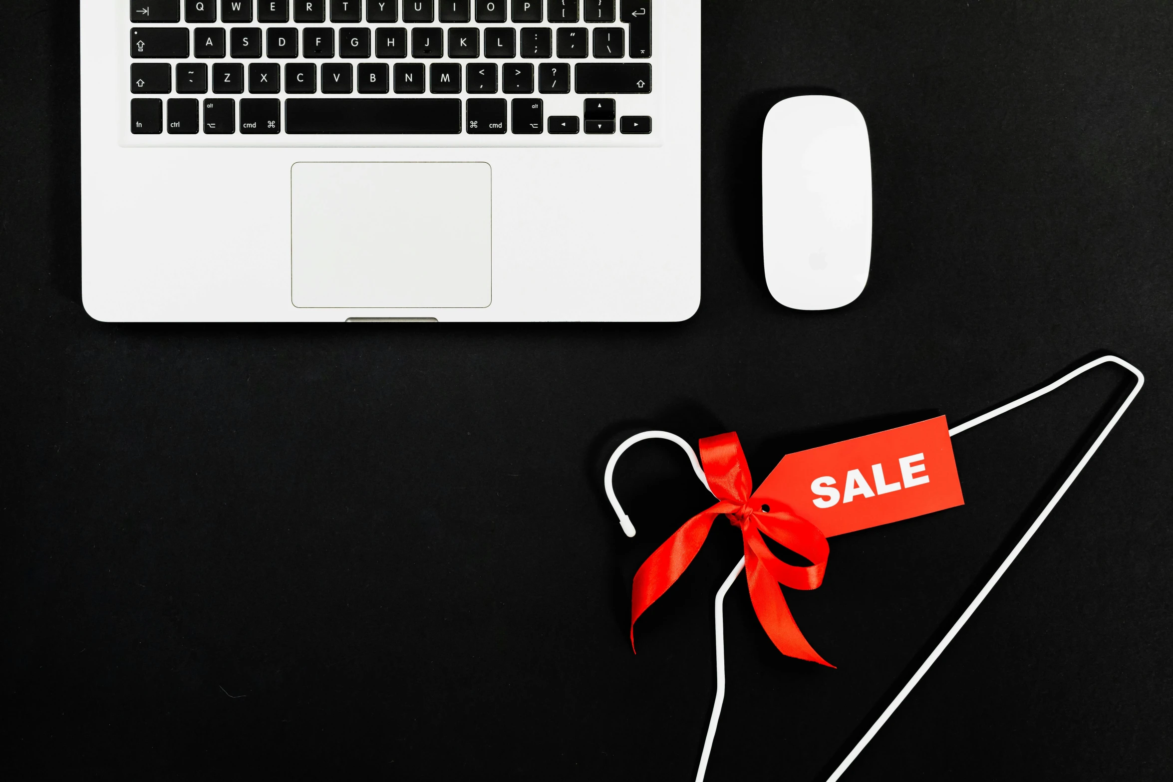 a laptop computer sitting on top of a desk next to a red sale tag, by Julia Pishtar, pexels, ribbon, black, holiday, link