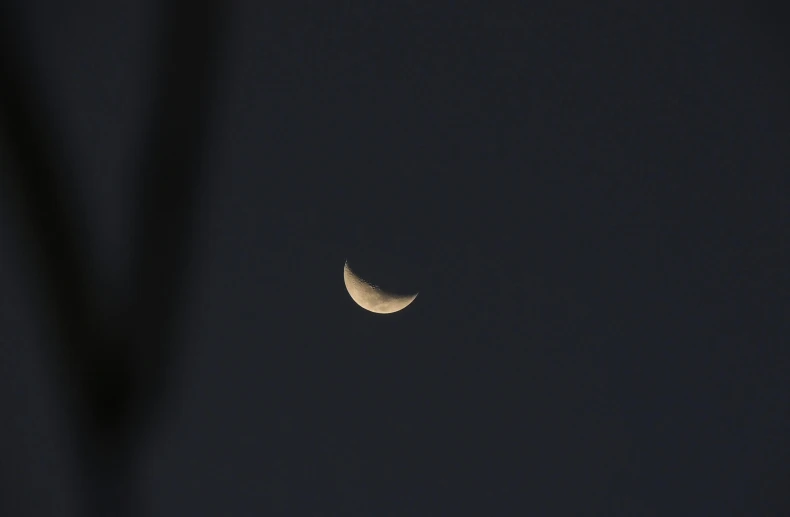 the moon is seen through the dark sky, an album cover, unsplash, hurufiyya, sickle, minimal canon 5 0 mm, ☁🌪🌙👩🏾, brown