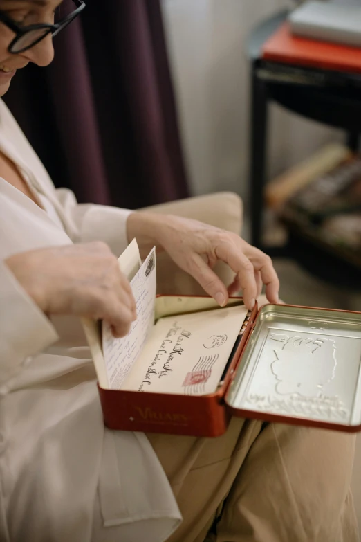 a woman sitting on a couch reading a book, an album cover, by Anita Malfatti, unsplash, looking at the treasure box, wedding, low quality footage, calligraphy