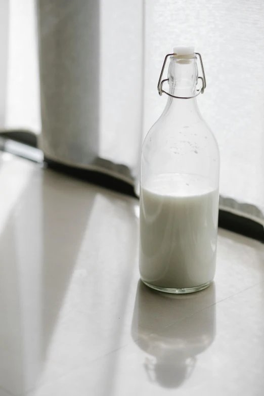 a bottle of milk sitting on top of a counter, by Tsuruko Yamazaki, unsplash, soft window light, background image, grain”, “organic