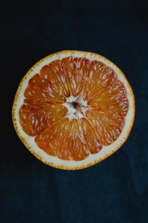 an orange cut in half on a blue surface, by Jesper Knudsen, pexels contest winner, hyperrealism, dark oranges reds and yellows, full of details, on a gray background, jen yoon