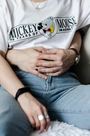 a woman sitting on a couch wearing a mickey mouse t - shirt, inspired by Elsa Bleda, trending on pexels, renaissance, an anthropomorphic stomach, lesbians, heavy gesture style closeup, cysts