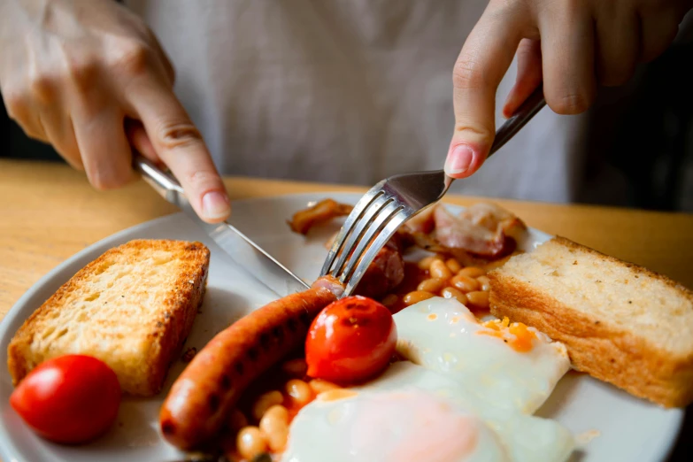 a person sitting at a table with a plate of food, by Joe Bowler, pexels contest winner, hearty breakfast, holding a crowbar, uk, dynamic closeup