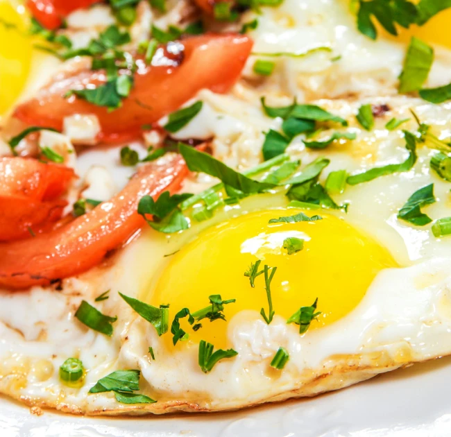 a white plate topped with eggs and tomatoes, by Niko Henrichon, shutterstock, profile image, sun drenched, cosmopolitan, ivy's