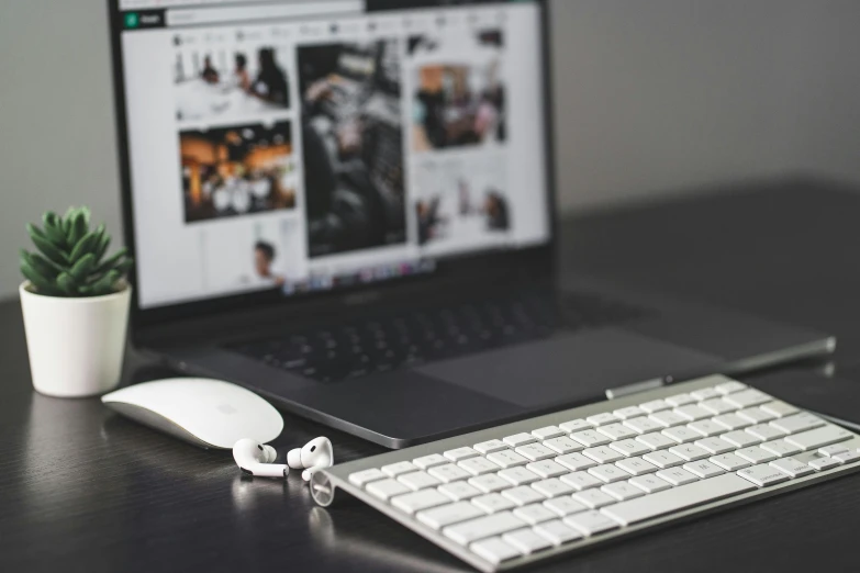 a laptop computer sitting on top of a wooden desk, a black and white photo, trending on pexels, earbuds jewelry, white mouse technomage, bringing people together, (night)