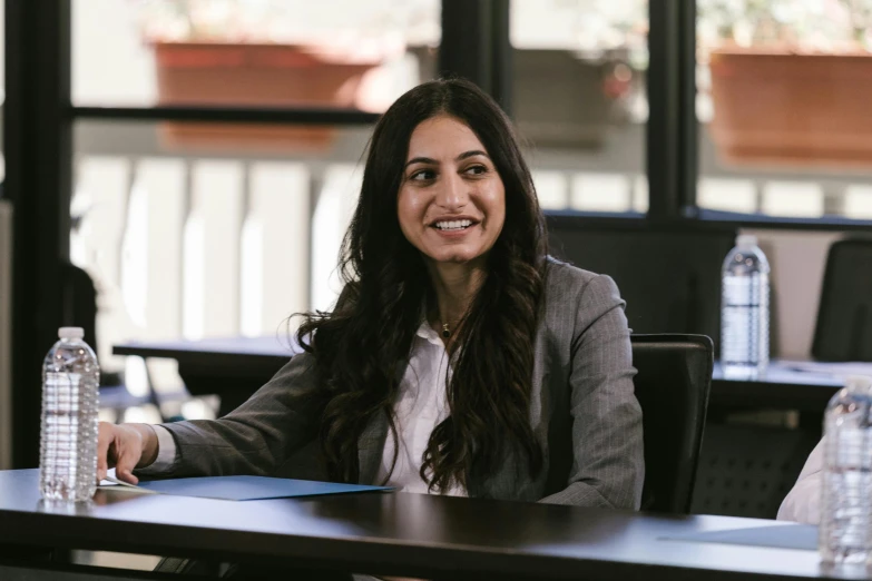 a woman sitting at a table with a bottle of water, kurdish lawyer, profile image, nivanh chanthara, avatar image