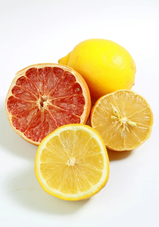 a group of lemons and grapefruits on a white surface, with a bright yellow aureola, half red, subtle detailing, organics