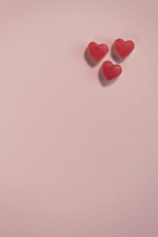 a couple of red hearts sitting on top of a pink surface, an album cover, by Elsa Bleda, trending on pexels, snacks, 15081959 21121991 01012000 4k, smol, blank