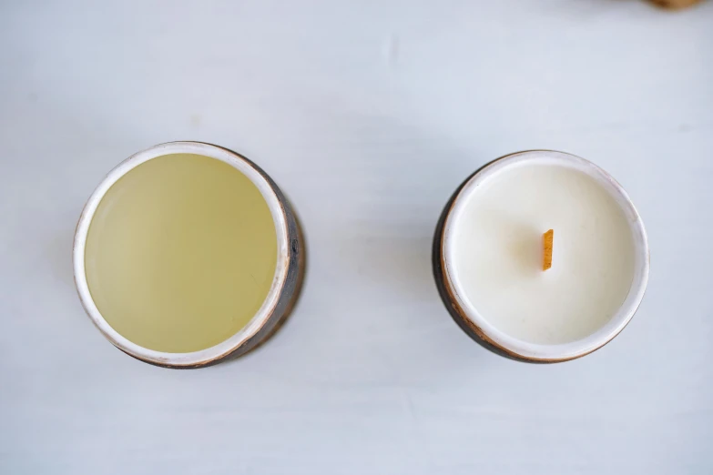 two candles sitting next to each other on a table, top down, glaze, well defined, 2 colors