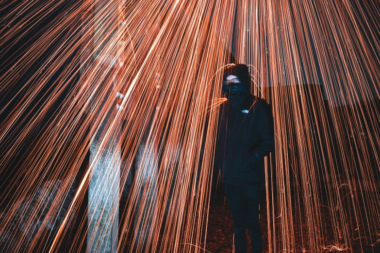 a man standing in front of a firework, a picture, pexels contest winner, light and space, covered with wires, photograph of a techwear woman, orange ray, low quality photo