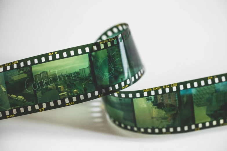 a roll of film sitting on top of a table, a picture, greenish expired film, movie poster with no text, movies, technicolour film