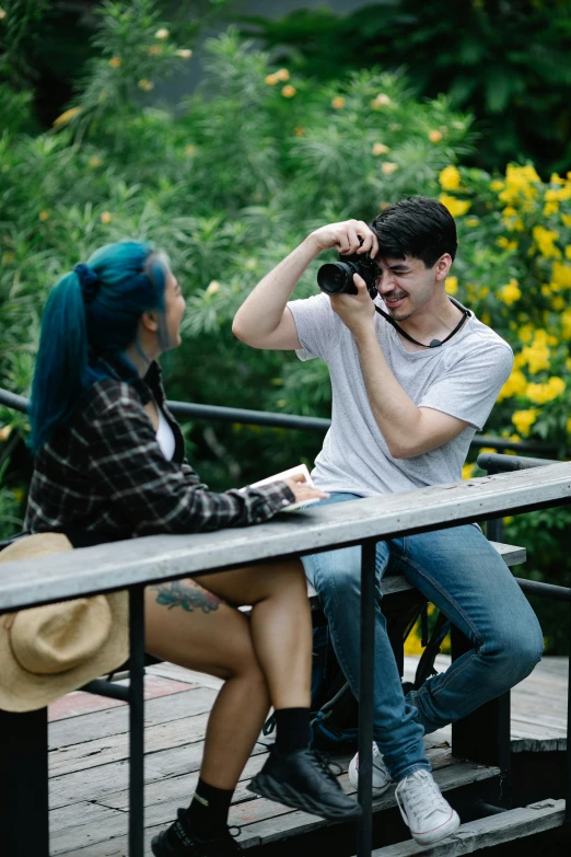 a man taking a picture of a woman sitting on a bench, non binary model, shot with sony alpha 1 camera, movie filmstill, college