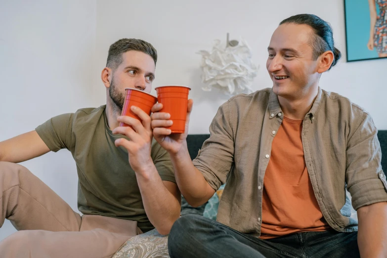 a couple of men sitting on top of a couch, pexels contest winner, awkwardly holding red solo cup, profile image, aussie baristas, college party